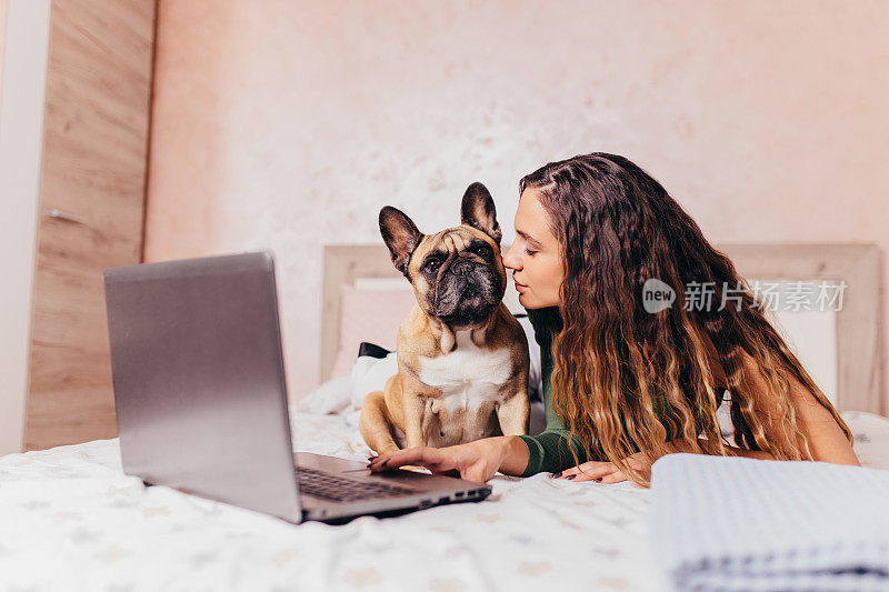 一个女人和她的狗在房子里。