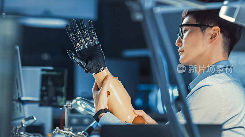未来的假肢机器人手臂正在测试由专业的日本开发工程师在高科技研究实验室与现代计算机设备。