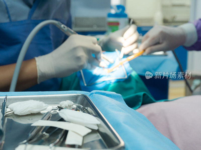 牙科诊所牙科椅上的牙科医生和模糊牙科医生检查病人牙齿的选择性聚焦牙科设备。医学口腔和牙齿保健理念。