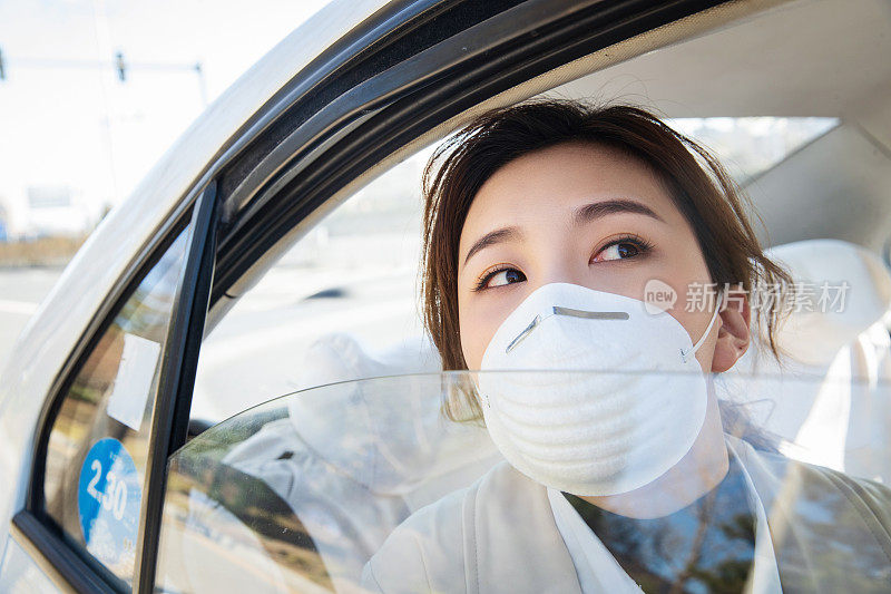 年轻女人戴口罩乘坐汽车