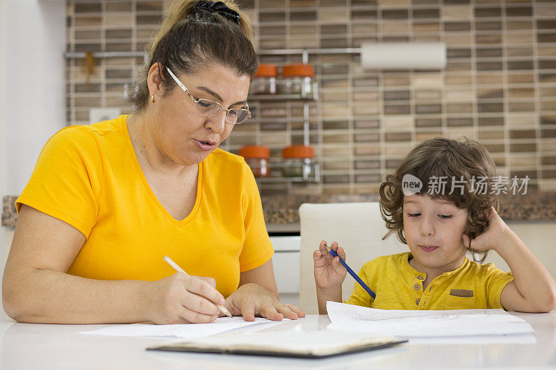 快乐的妈妈教她的小儿子如何写快乐的妈妈教儿子写和画