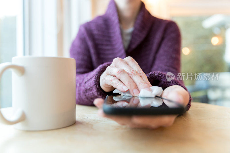 女性用抗菌白色纸巾或一次性湿巾清洁智能手机显示屏