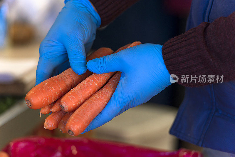 戴着橡胶手套的蔬菜水果商。