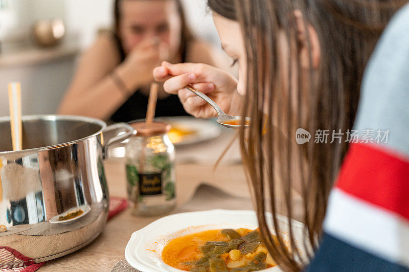 年轻女孩在家里喝蔬菜汤