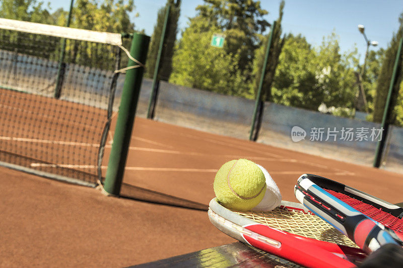 网球拍和球，在一个砖灰的球场上。网球的概念。