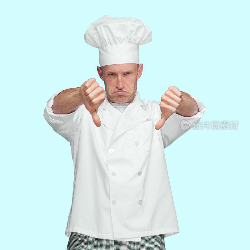 白种年轻男厨师穿着夹克站在蓝色背景前