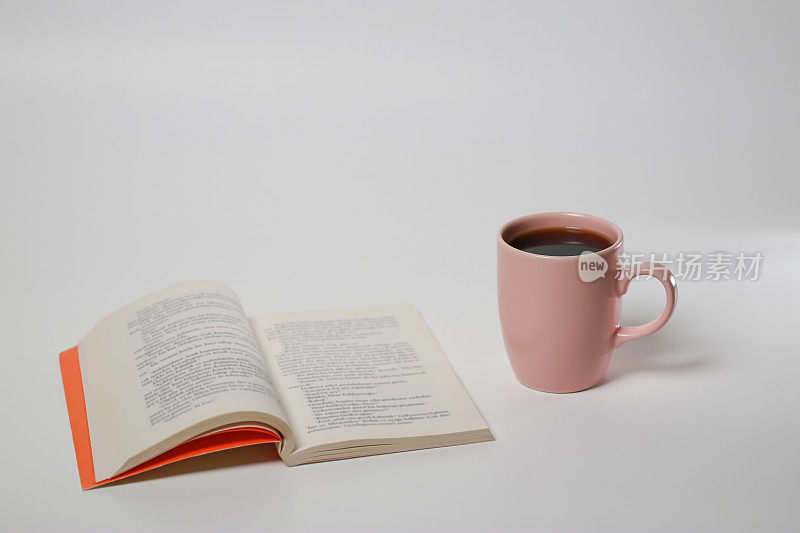 书和粉色咖啡杯在白色孤立的背景