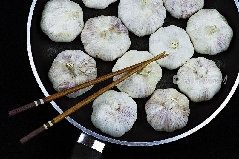 锅里放大蒜和筷子。