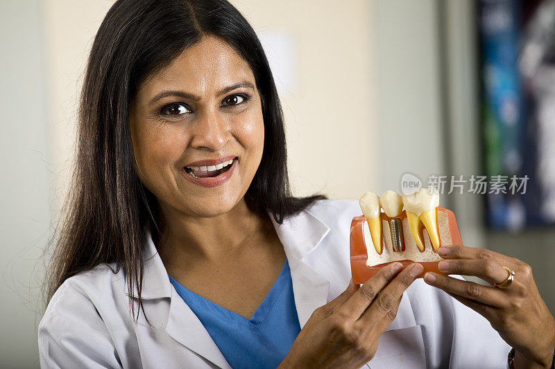 女牙医在牙科诊所展示假牙