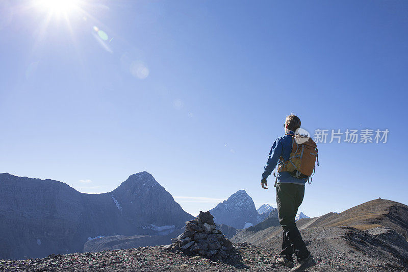 年轻人早晨沿着山脊徒步旅行