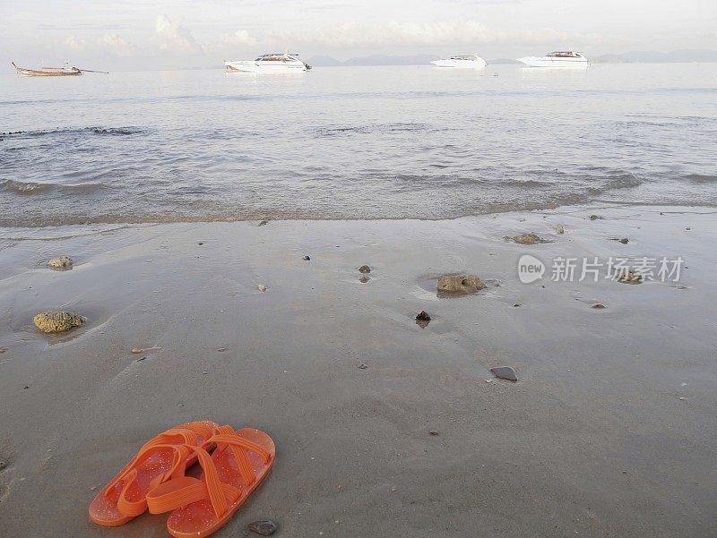 沙滩上的橙色凉鞋