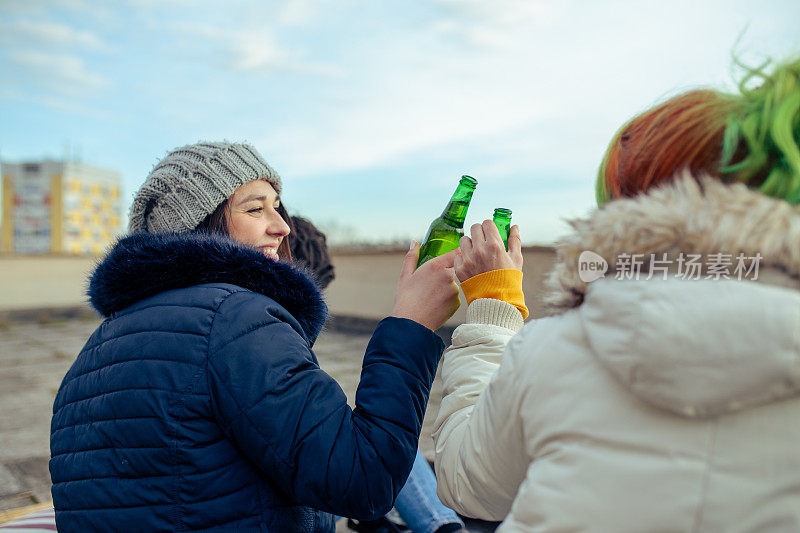 两个年轻女人喝啤酒敬酒