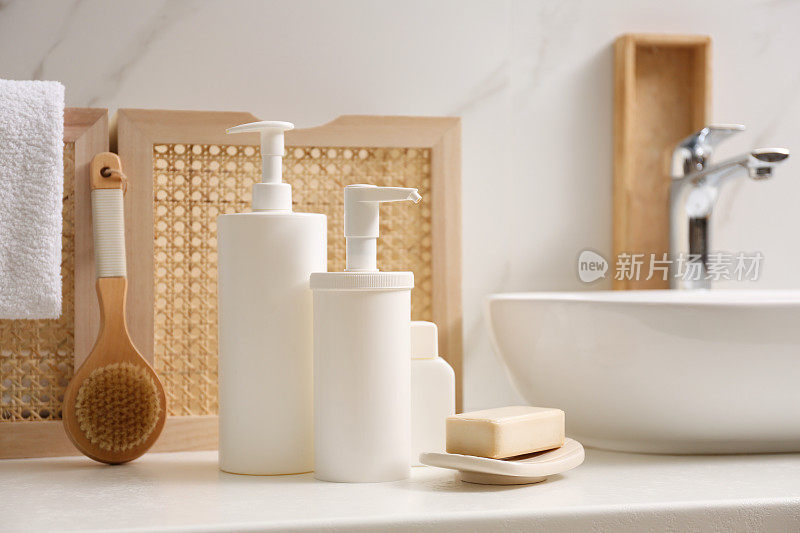 洗漱用品和个人卫生用品放在浴室的白色台面上