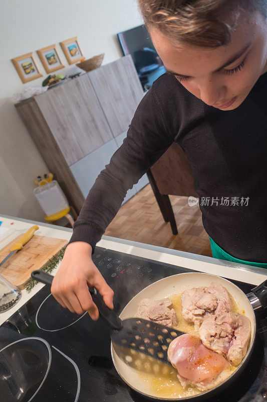 十几岁的男孩在家庭厨房做鸡肉和蔬菜午餐