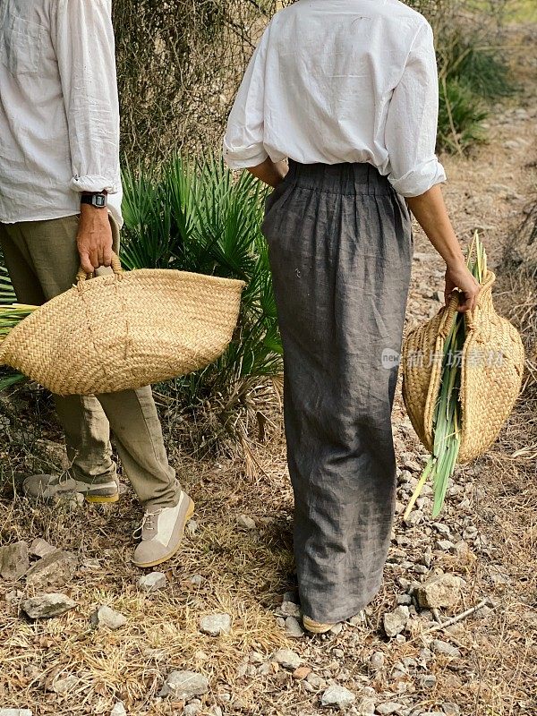 一个女人打扮成农民的样子，提着草篮在田野里散步