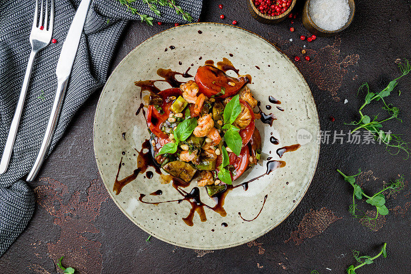 蔬菜沙拉，蘑菇，西红柿和炸虎虾在深色混凝土桌面视图