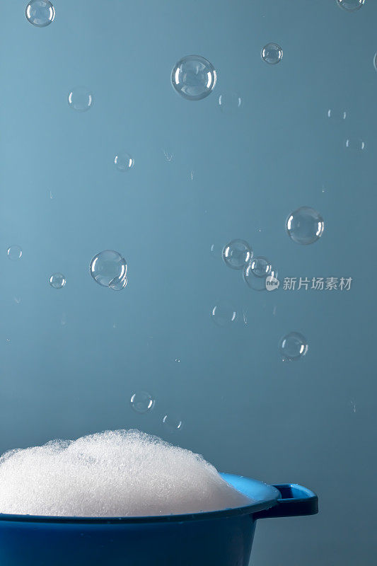 肥皂放在碗里，蓝色背景上有泡沫