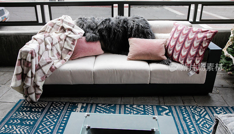 户外露台沙发与粉红色天鹅绒民主枕头和一个扔与柔和的冬季气氛