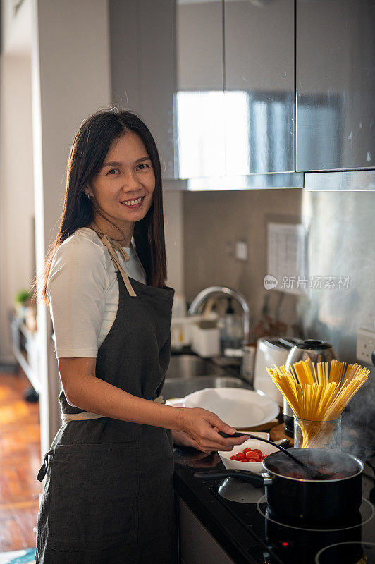 有吸引力的亚洲中国女人在厨房做饭