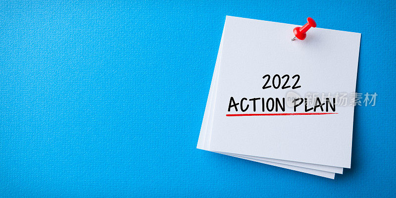 白色便利贴与新的2022年行动计划和红色图钉在蓝色背景