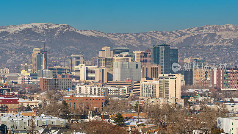 俯瞰中层建筑朝向SLC的市中心塔楼，背景是雪山