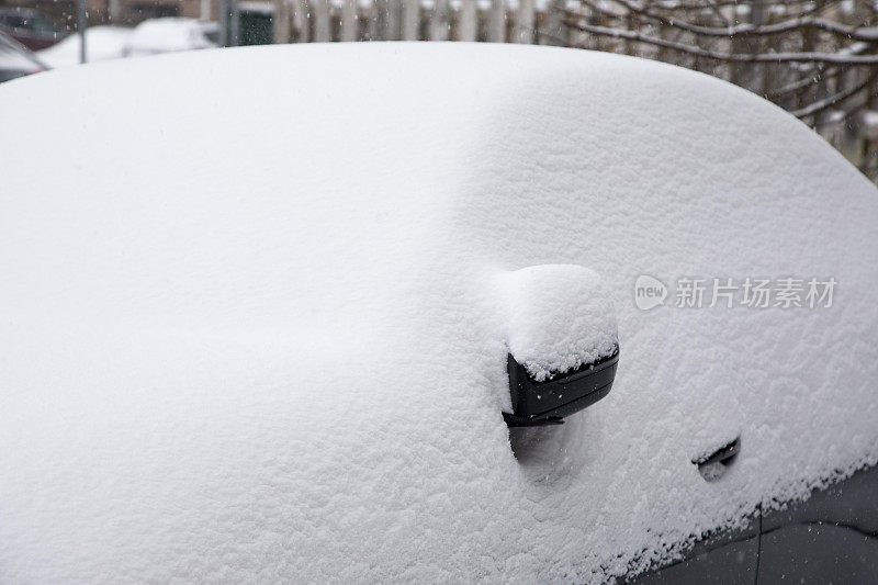 在冬天的暴风雪中被雪覆盖的汽车