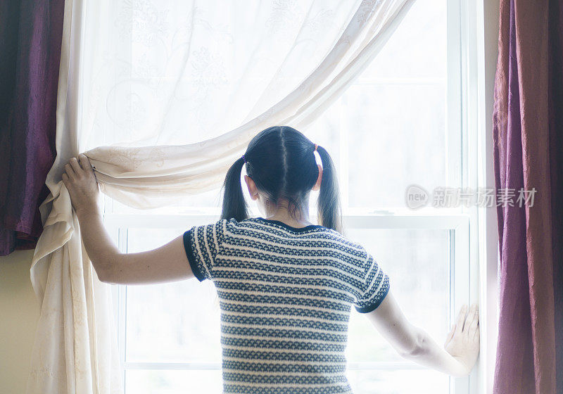 一个少女往窗户里看