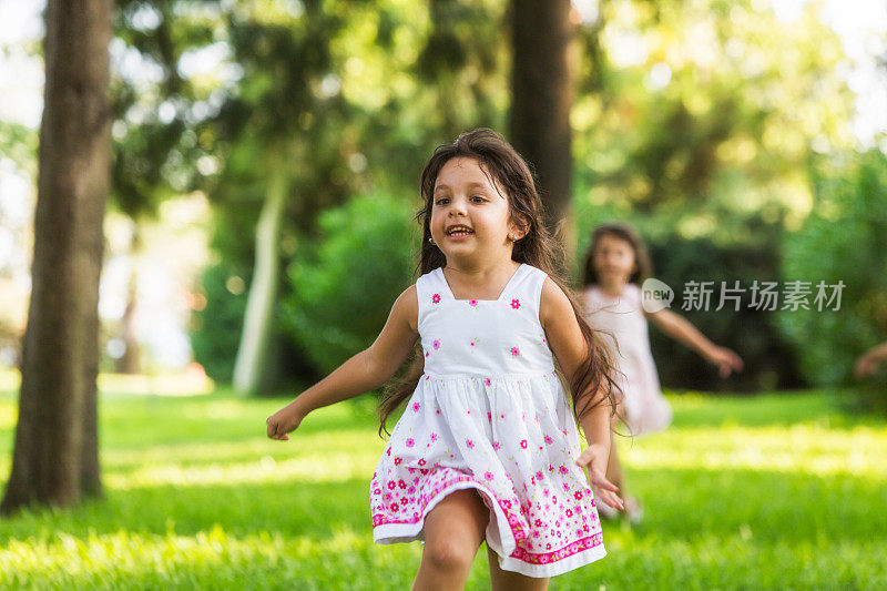 在阳光明媚的夏日，女孩们在公园里跑步