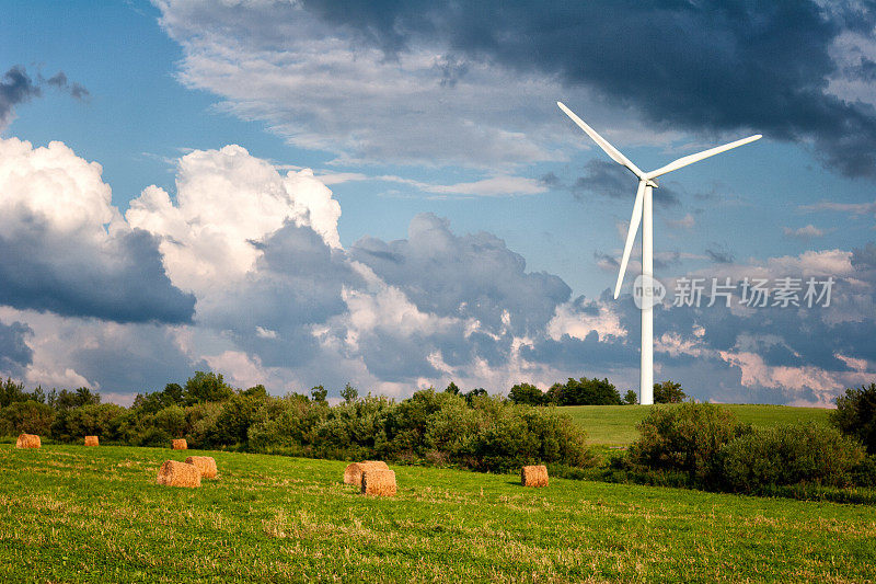 风力发电机，干草捆和壮观的天空