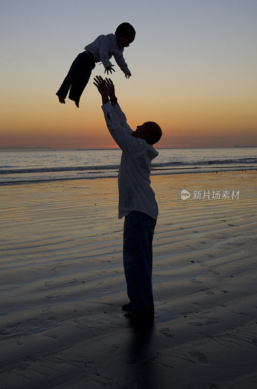 夕阳西下时，父亲将小儿子抛向空中