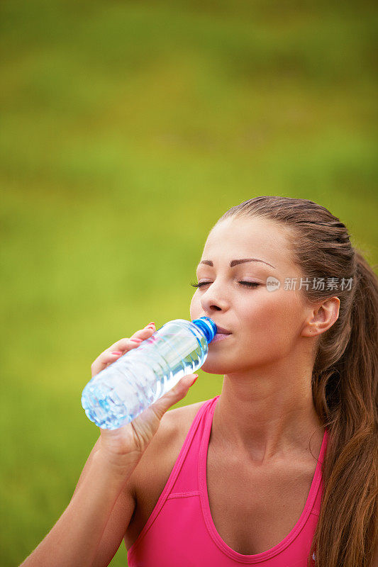 喝瓶子里水的女人