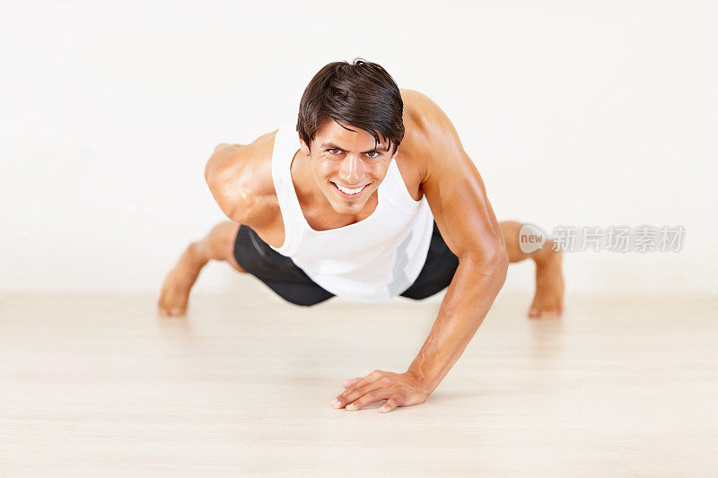 一个年轻人在健身房做单手俯卧撑