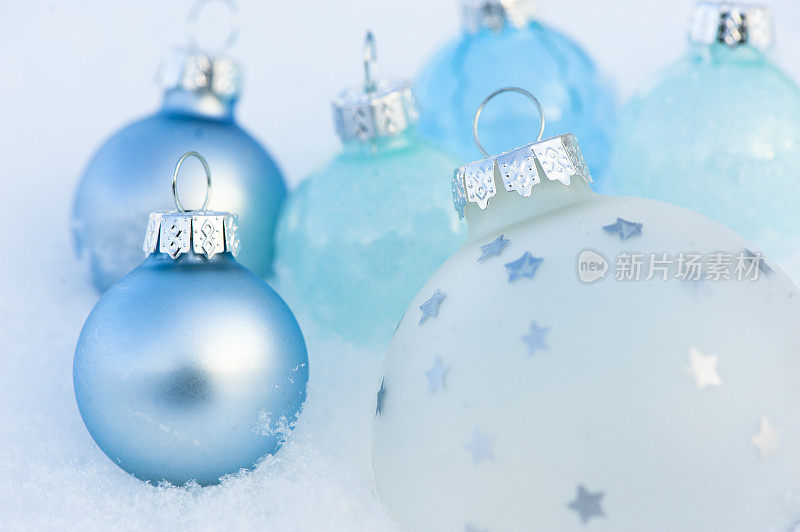 雪花上蓝色圣诞装饰品的特写。