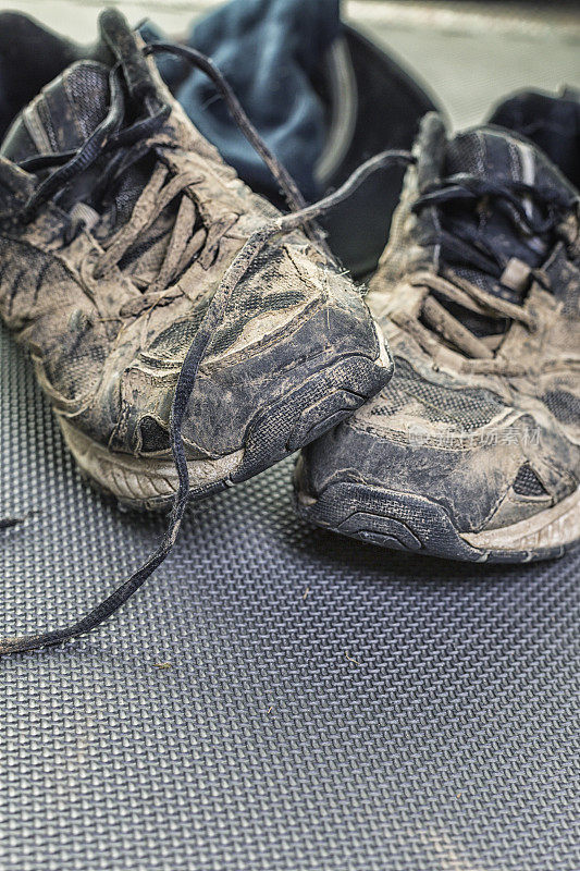 泥泞的破旧的运动跑鞋