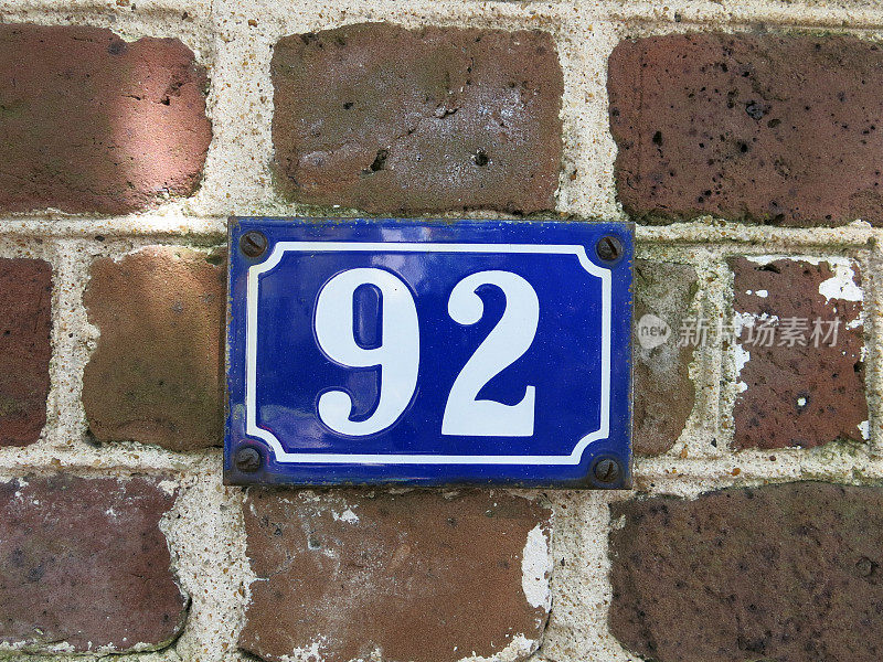 砖砌外墙上的蓝色和白色白宫编号
