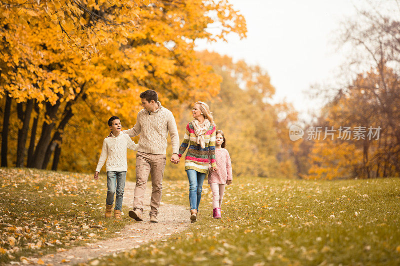 一家人走在秋天的小路上