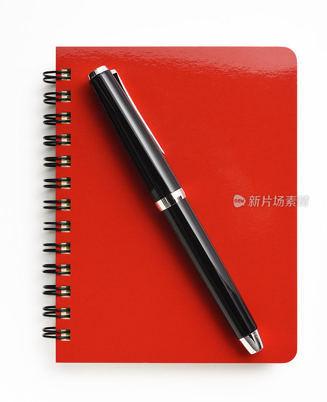 白色背景上带钢笔的闭合的红色螺旋式笔记本