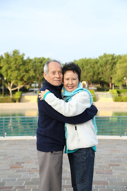 年长的亚洲夫妇拥抱在一起