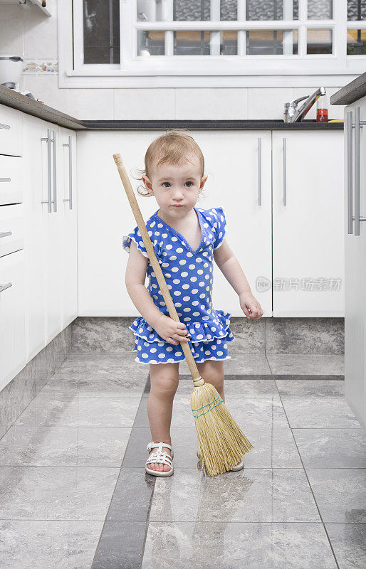 小女孩在厨房打扫地板