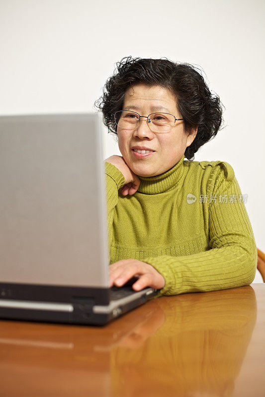 成熟的女人在家里使用笔记本电脑