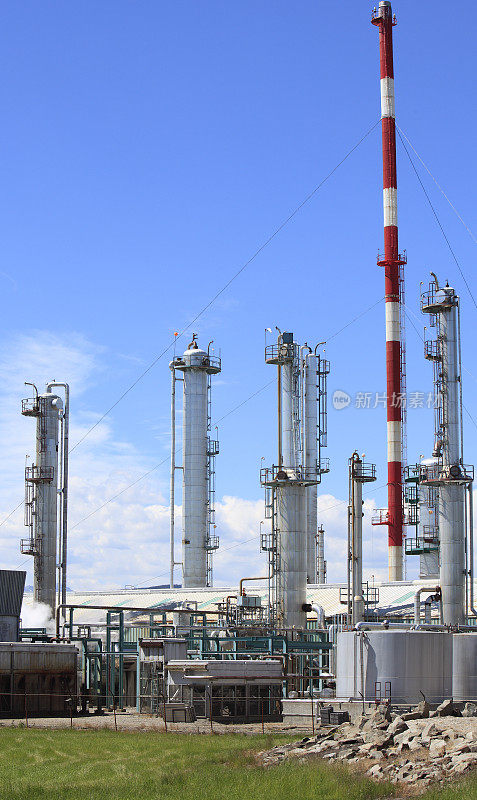 银色气体工厂塔与红色和白色的烟囱