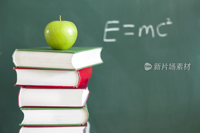 回到学校:绿苹果坐在教育课本上