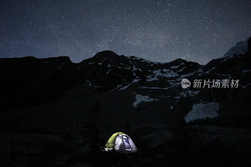 星星覆盖了山巅的夜空和明亮的帐篷