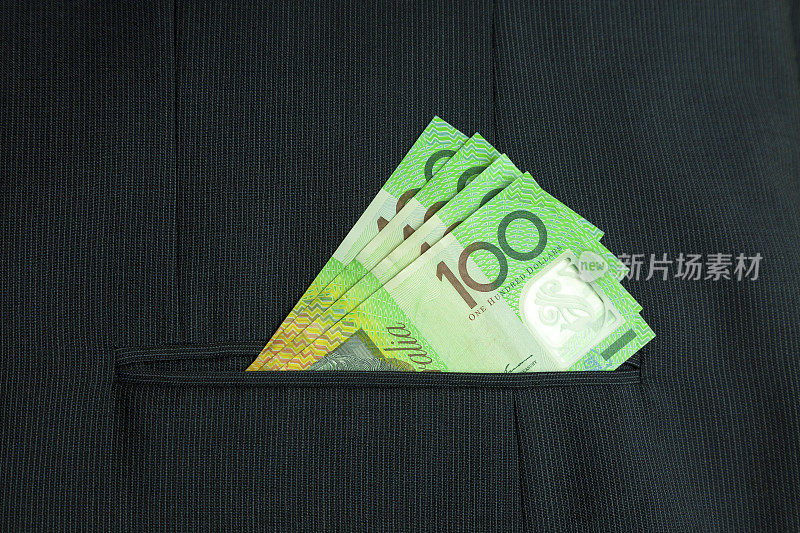 企业现金:100美元纸币在细条纹西装口袋