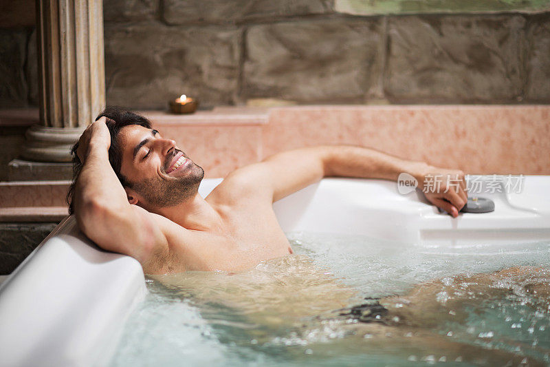 在热水浴缸里放松的男人。