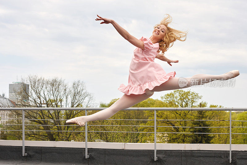 年轻的白人时尚芭蕾舞演员在屋顶上跳跃