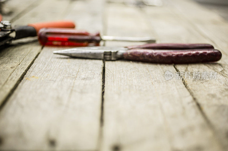 木制工作台上的施工工具包括钳子、螺丝刀。