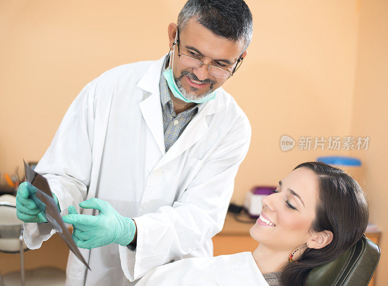 牙医给女病人看牙科x光片
