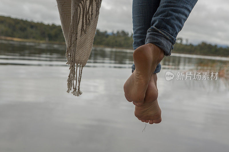 女人的脚在湖边码头上晃荡