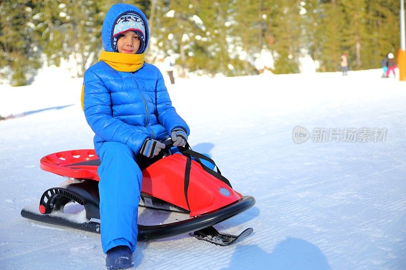 小男孩和他的雪橇在冬天